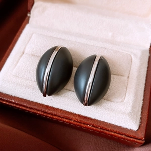 Macro shot of French vintage oval wood grain texture earrings with silver metallic stripe