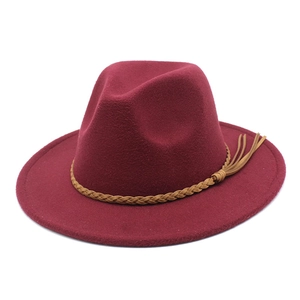 Detail of dark wine red wool fedora hat with brown braided band and tassel accent