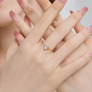 Close-up of adjustable gold chain ring with pear-shaped clear zircon on model's hand