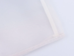Detail of white organza shirt showing fine mesh texture and precise edge stitching