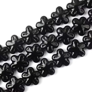 Vista macro di perle in ceramica nera a forma di fiore per la creazione di gioielli