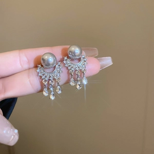 Macro shot of silver pearl tassel earring with crystal drops and sparkling pavé details