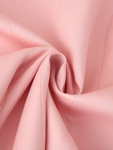 Close-up of pink woven fabric texture showing fine stitching and high-quality material drape