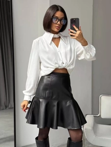 Vue détaillée d'une jupe en similicuir noir à taille haute avec ourlet à volants et chemisier