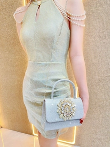 Elegante borsa da sera con paillettes d'argento e fiori di cristallo indossata da modella