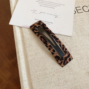 Dettaglio macro di un fermaglio per capelli vintage leopardato su uno sfondo neutro