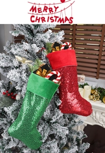 Detailed view of sequined Christmas stockings with gift boxes hanging on a tree