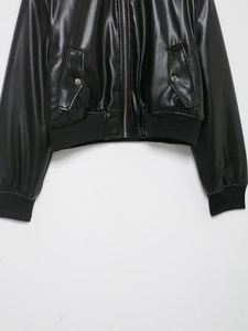Close-up of ribbed hem and sleeve cuffs on a black faux leather bomber jacket