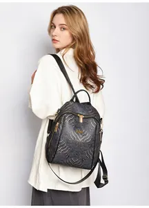 Close-up of black and gold wave pattern fabric with metallic logo on chic backpack