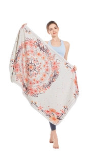 Detail of a large microfiber beach towel featuring a vintage orange floral mandala design