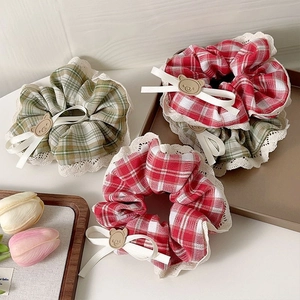 Three plaid lace scrunchies with cute bear charms and cream bows on a wooden tray