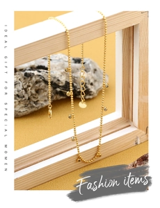 Detailed macro view of a gold-plated bead necklace with white zircon on a wooden frame