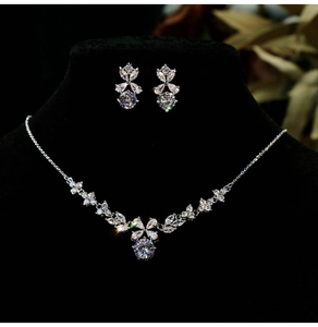 Macro shot of silver bridal jewelry set with zircon flowers on a black display stand