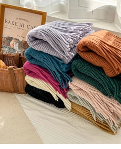 Detail shot of multi-color knitted scarves with fringe textures and warm winter tones
