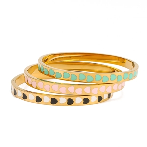 Three stacked 18K gold stainless steel bracelets with colorful enamel heart patterns