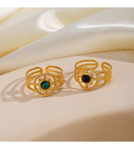 Detailed close-up of vintage rudder-style gold rings with malachite and obsidian stones