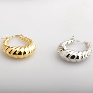 Textured hollow twist hoop earrings in gold and silver finish on a clean white background