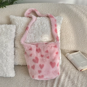 Close-up of pink plush bucket bag featuring soft faux fur and sweet heart patterns