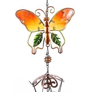 Close-up of butterfly wind chime with orange glass wings and green metal accents