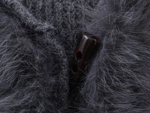 Detailed macro view of grey knit texture with faux fur trim and classic toggle button