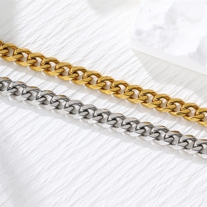 Macro shot of gold and silver stainless steel Cuban link necklaces on stone background