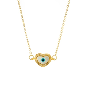 Macro detail of gold heart pendant with shell evil eye and sparkling zircon stones