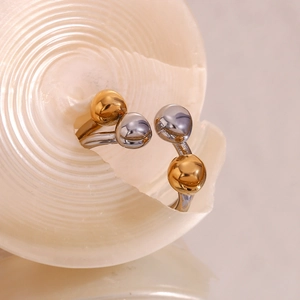 Detailed macro of a two-tone 18K gold plated steel ring on a white decorative shell