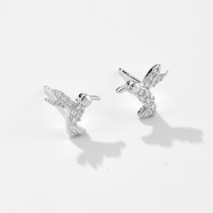 Macro detail of silver hummingbird stud earrings with sparkling white zircon inlay