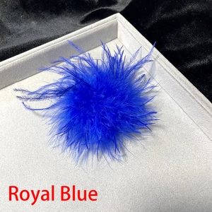 Detailed macro view of vibrant royal blue ostrich feather brooch on a gray display tray