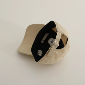 Detail of adjustable strap and metal buckle on the khaki embroidered cotton baseball cap