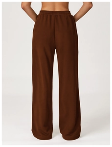 Detail of high waist elastic waistband on brown wide-leg sweatpants showing fabric texture
