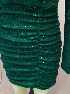Detailed close-up of dark green sequin bodycon dress with ruching textures and slim fit design