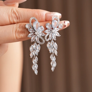 Detailed macro view of sparkling zircon flower tassel earrings in elegant silver finish
