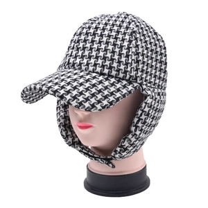 Detail of classic houndstooth winter trapper hat with ear flaps on a model head