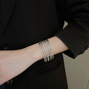 Detail of silver multi-layer open bangle featuring polished and textured metal bands