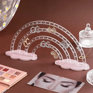 Detailed view of rainbow acrylic earring stand with pink cloud base and multiple holes