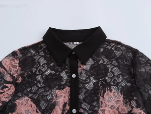 Detail view of the lace shirt collar with pink floral patterns and black button placket