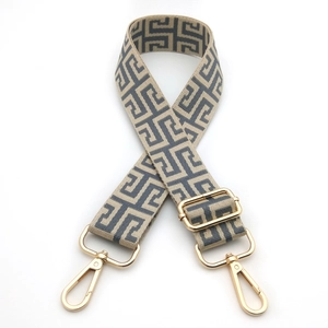 Detail of adjustable beige and grey geometric shoulder strap with gold metal hooks