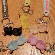 Cinque portachiavi a forma di orso opaco in nero, giallo, rosa, blu e viola su legno