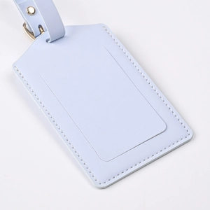 Detail of light blue PU leather luggage tag with fine stitching and metallic buckle