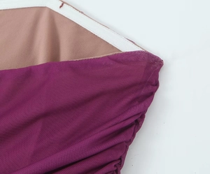Dettaglio ravvicinato del tessuto a rete viola plissettato con fodera interna beige