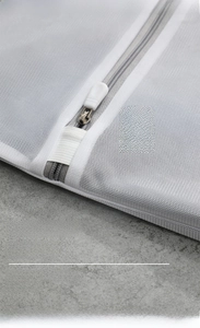 Detail of white laundry bag with gray hidden auto-lock zipper to protect clothes