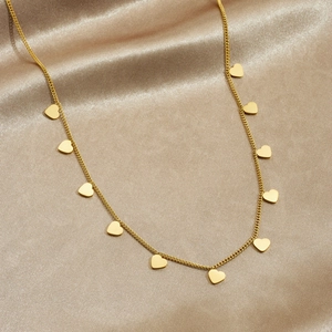 Minimalist gold plated stainless steel necklace featuring multiple heart pendants on silk