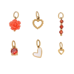 Detail view of six gold heart and rose charms with red gems and white stones