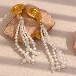 Detail of 18K gold snail stud earrings with elegant long white pearl tassels