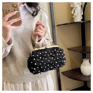 Détail de sac de soirée en dentelle noire avec roses 3D, perles et fermoir doré
