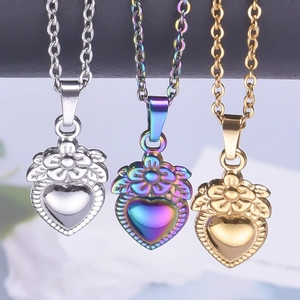 Three heart pendants with floral engraving in silver, gold, and iridescent steel finish