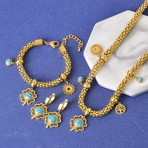Gold-plated jewelry set featuring turquoise clover and ginkgo pendants on blue background