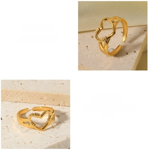 Detail of adjustable hollow heart gold ring featuring dual heart cutout on stone background