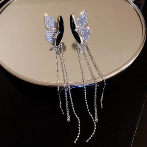 Macro detail of silver butterfly earrings with black enamel and dangling rhinestone fringe